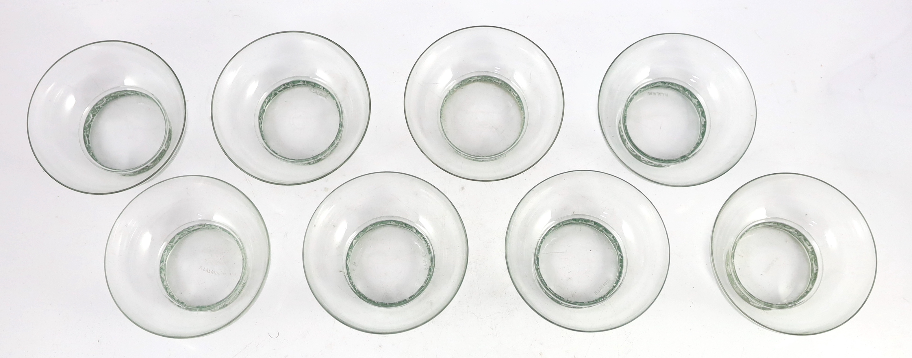 A set of eight R. Lalique Dampierre pattern bowls, model no. 3136, designed 1932, each moulded with a blue stained band of birds around the base, etched mark, 12.1cm diameter one bowl with tiny rim chip